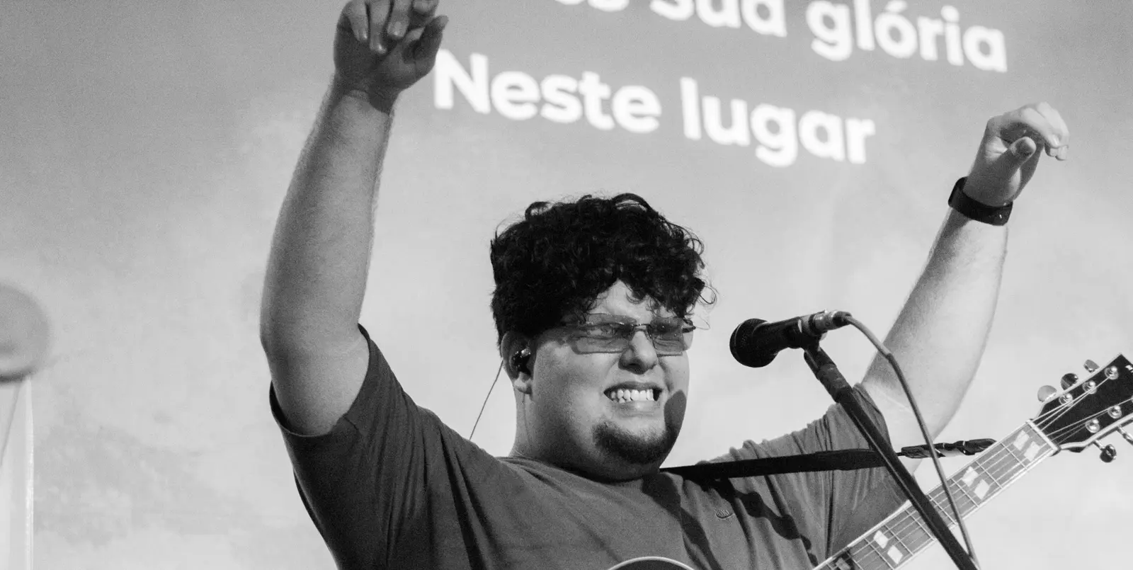 Jovem adorando com os braços levantados no Culto Fire